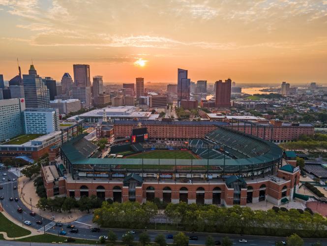 a view of Camden yards baseball field with the city of Baltimore in the background at sunset
