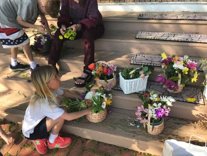 Kids creating their own May Day Baskets on their front porch stairs.