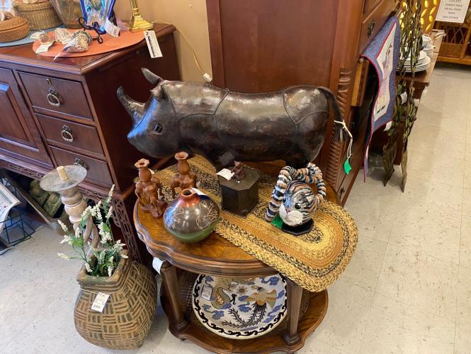 A Rhino foot stool and other vintage collectibles on a table.