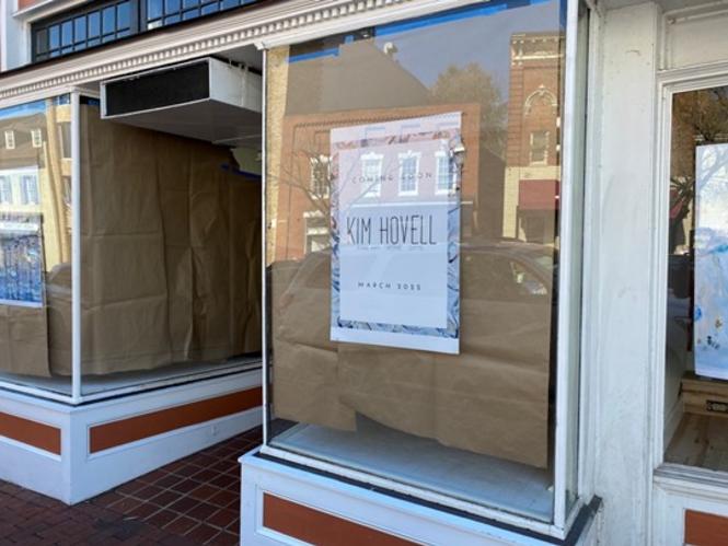 A storefront with brown paper in the windows announcing the arrival of Kim Hovell Studio