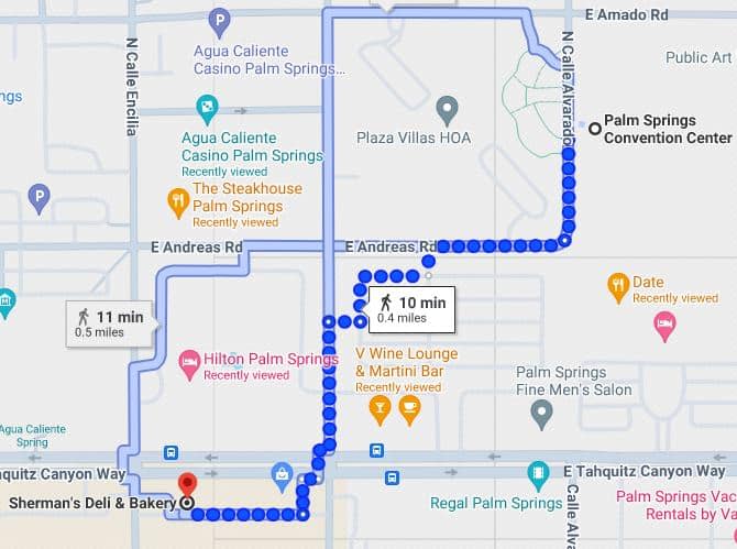 A map screenshot showing a walking route in Palm Springs with marked points of interest, including the Agua Caliente Casino, The Steakhouse, Hilton Palm Springs, and V Wine Lounge, with estimated walking time.