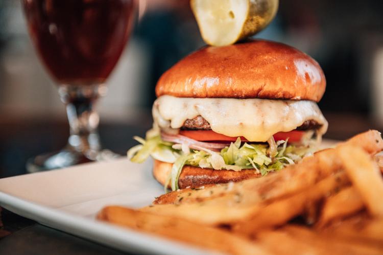 Burger with french friends and beer in background at City Works