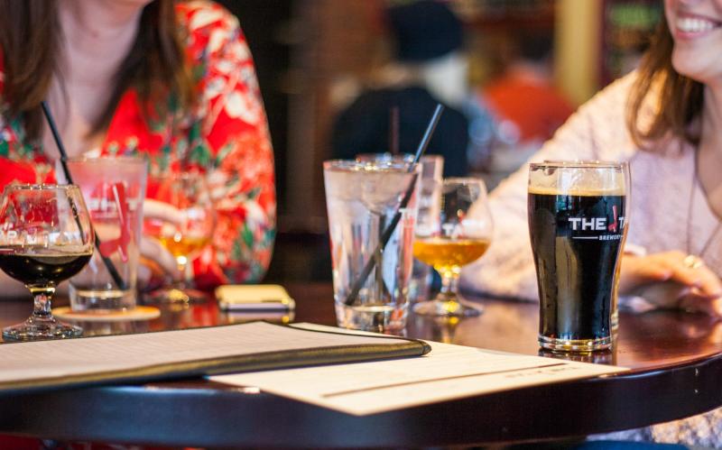 Two women sitting at a table full of drinks at The Tap