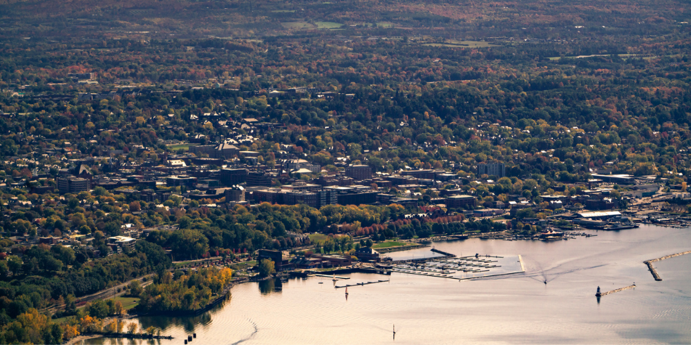 View from an Airplane flying over Burlington, VT with the city scape and Lake Champlain in the foreground.