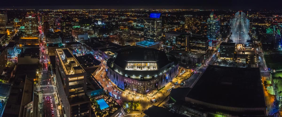 Aerial view at night of Golden1 Center, the Kimpton, and the downtown skyline.