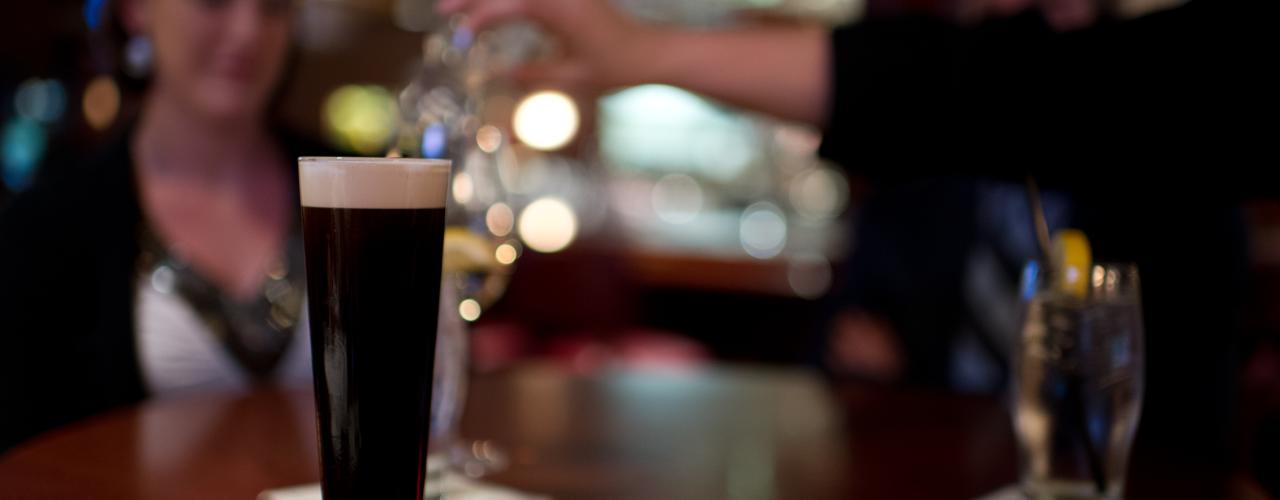 Dark beer on wood table indoors