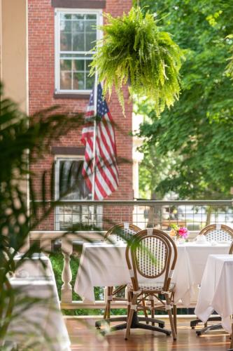 Looking off the side of the front porch past a wicker chair and hanging fern