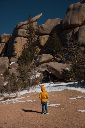 child in front of large granite rocks
