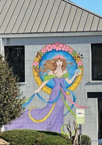 A mural of a beautiful woman in a purple, off-the-shoulder dress