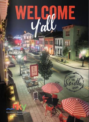 This magazine cover shot features a photo of Mainstrasse at night, with red striped umbrellas and cafe tables set up along the sidewalk