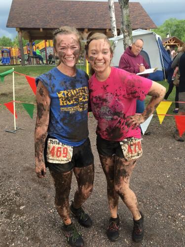 Two women covered in mud at the end of the Tofte Trek race.