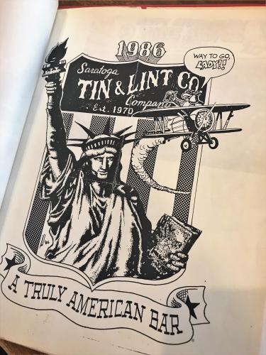 1986 pen and ink ad for Tin and Lint featuring Statue of Liberty and old plane