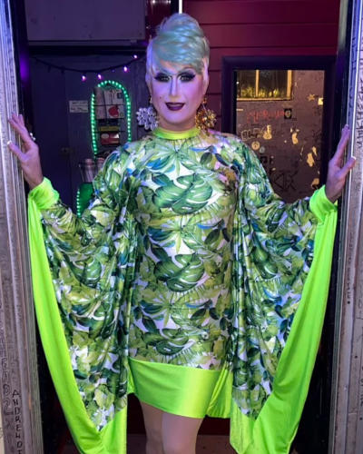 Jacqueline Daniels Drag Queen in a green dress with long sleeves.
