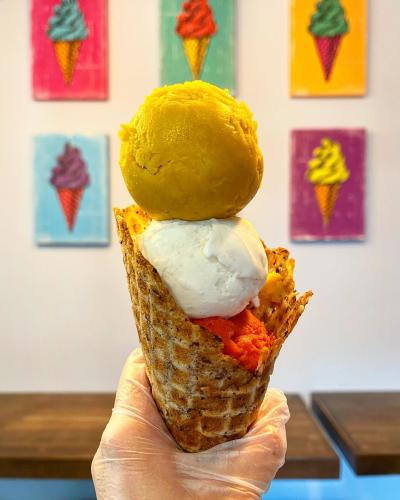 High stacked ice cream, multiple flavors, in a cone