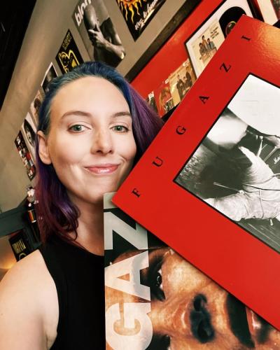 Katie Scott - owner of Red Zeppelin holding up Fugazi red album cover