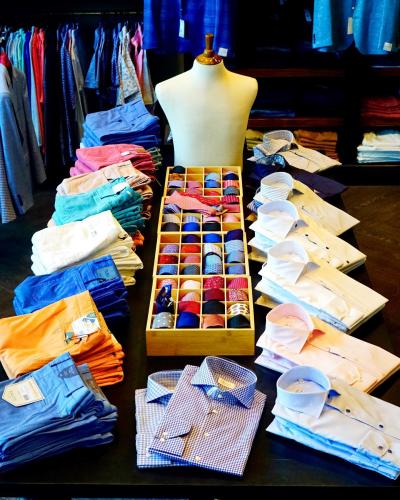 Arrangement of shirts and colorful shorts on a dark tabletop.