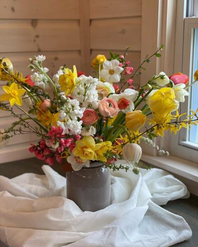 Tin vase of wildflowers on white fabric