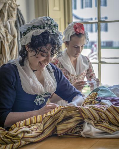 Interpreters working on a gown in the Margaret Hunter Millinery Shop