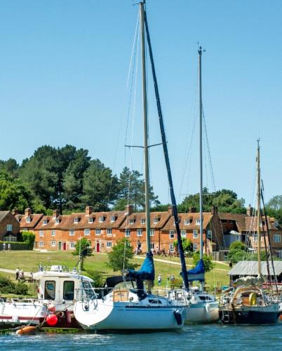 Portrait view of Bucklers Hard from the water with boats in the foreground