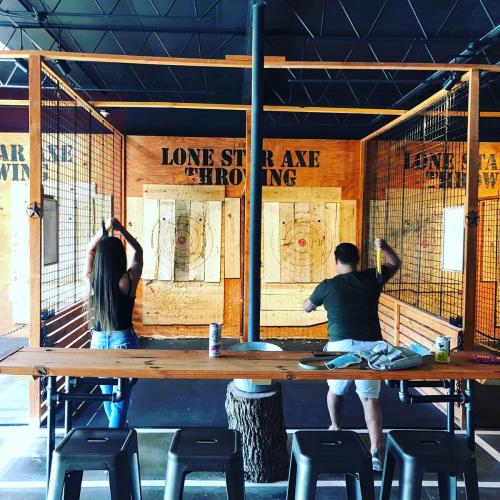 Two people throwing axes at Lone Star Axe Throwing