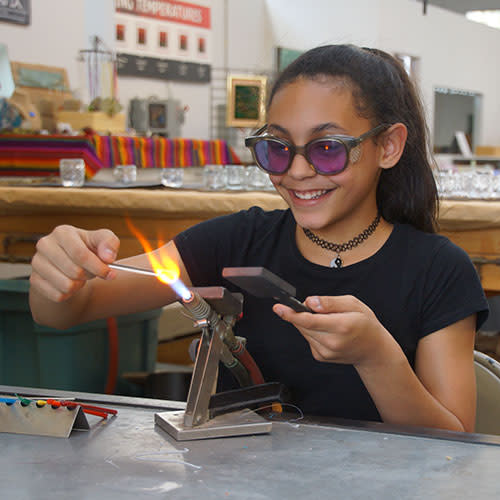 Girl blowing glass at Glass Axis in Franklinton