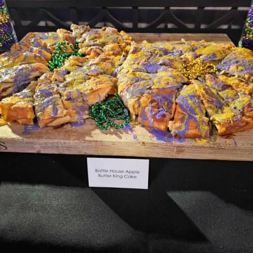 Battle House apple butter king cake with purple icing and green Mardi Gras beads