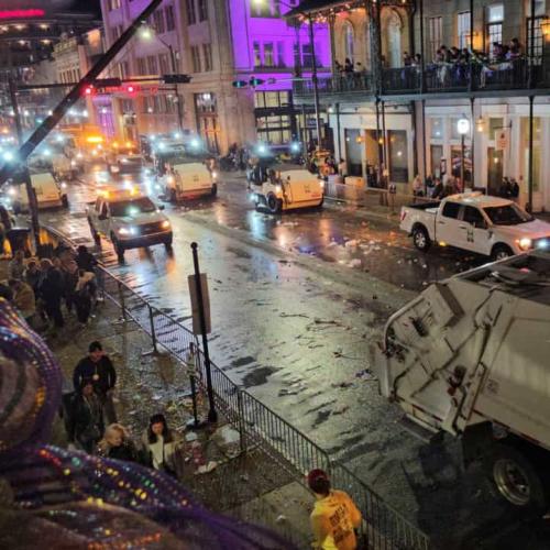 City workers and vehicles clean and sweep streets after Mardi Gras parade