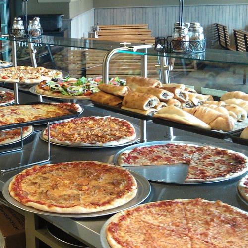 Countertop display filled with pizzas and stromboli