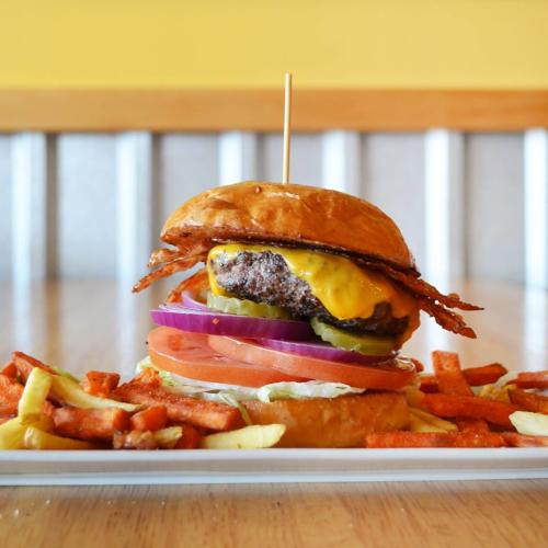 Juicy Burgers & More plate with giant bacon cheeseburger and fries