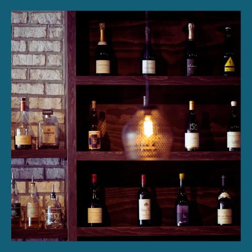 3 shelves of wine set up against an interior brick wall