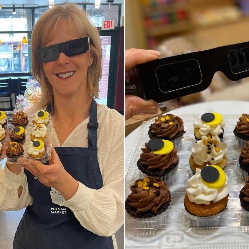 cupcakes decorated with frosting and sun and moon for eclipse, woman wearing eclipse viewing glasses