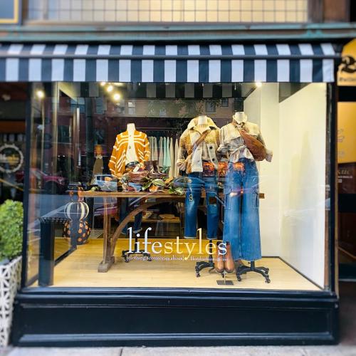 storefront window with fall clothes on mannequins