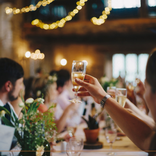 Hand holding champagne glass in a wedding toast