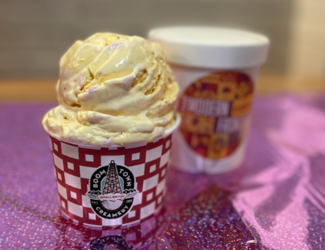 A scoop and pint of ice cream sitting on a table at Boom Town Creamery