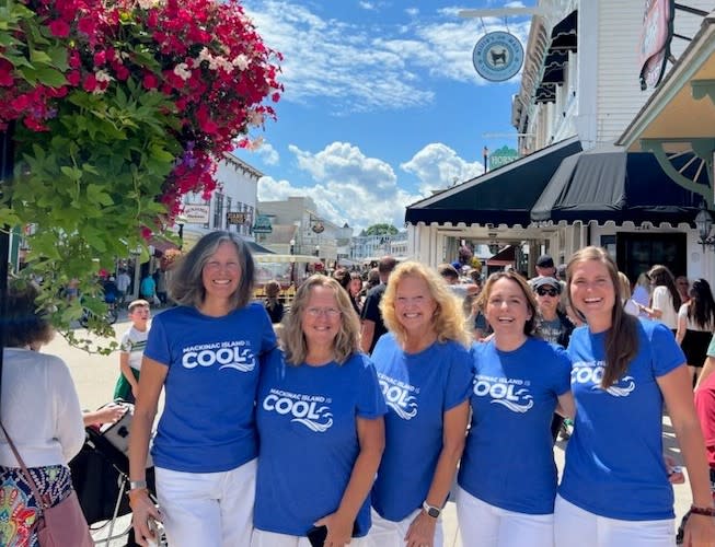Handful of Mackinac Island Tourism Bureau information specialists wearing ‘Mackinac Island is COOL’ shirts