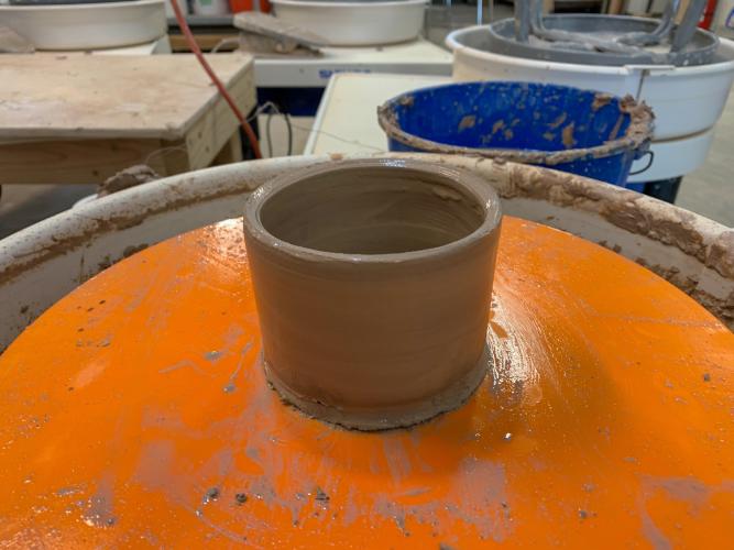 Small and wet clay cup on Potter's Wheel
