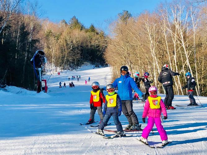 West Mtn. father and 3 kids on skis on the slope