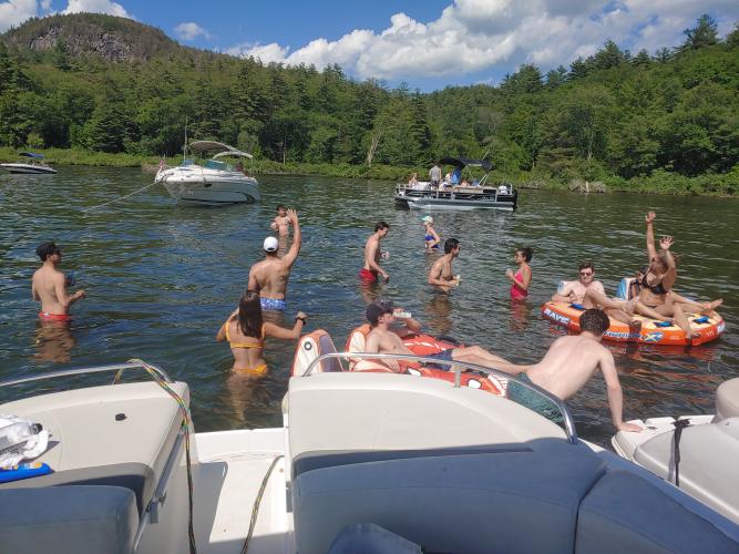 Group standing in water off of Daley's pontoon