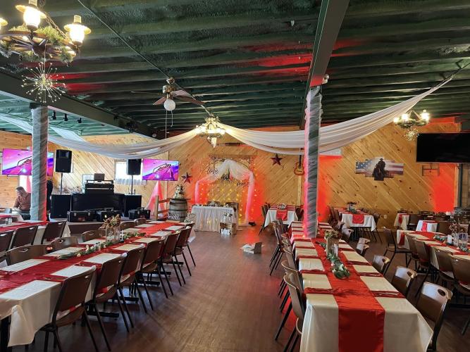 Tables and decor set up for wedding, red table runners, white draping on the ceiling