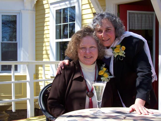 Couple posing together outside of Saratoga Farmstead b & b with a glass of champagne