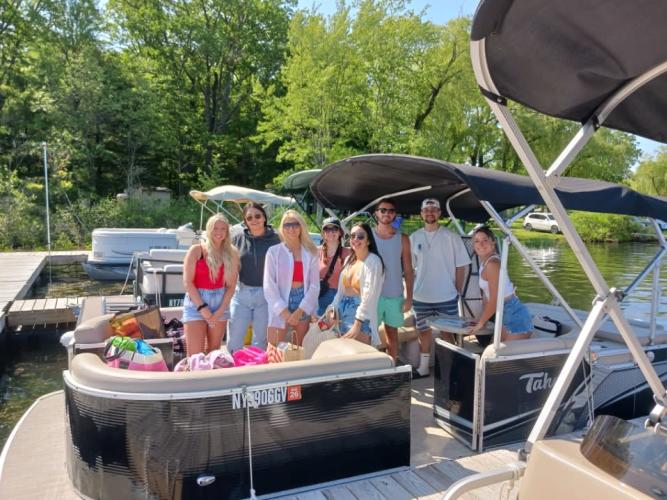 Group of people standing to post on pontoon on the lake