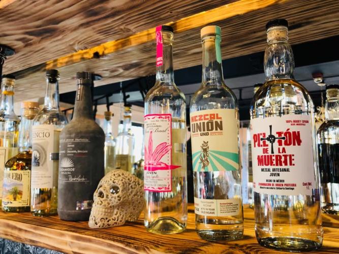 Tequilas on shelf behind bar with a skull in the middle