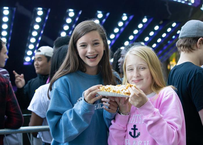 Two children smiling and enjoying cheese fries at Dunwoody Lemonade days
