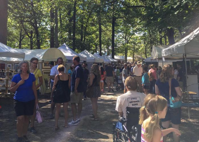 Festivalgoers browse artist booths along a wooded path at the Monte Sano Arts Festival in Huntsville.