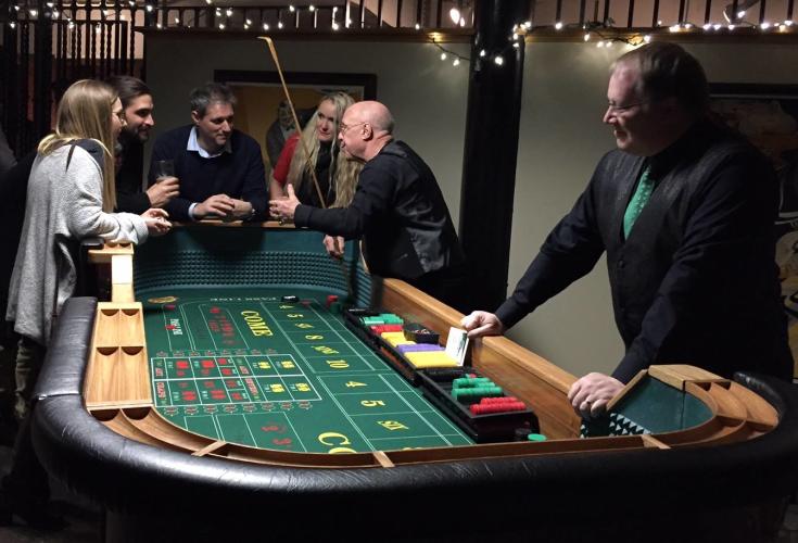 Alpine Amusement Group of people around a gaming table placing their bets.
