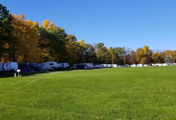 Expansive green field with campers lined on perimeter