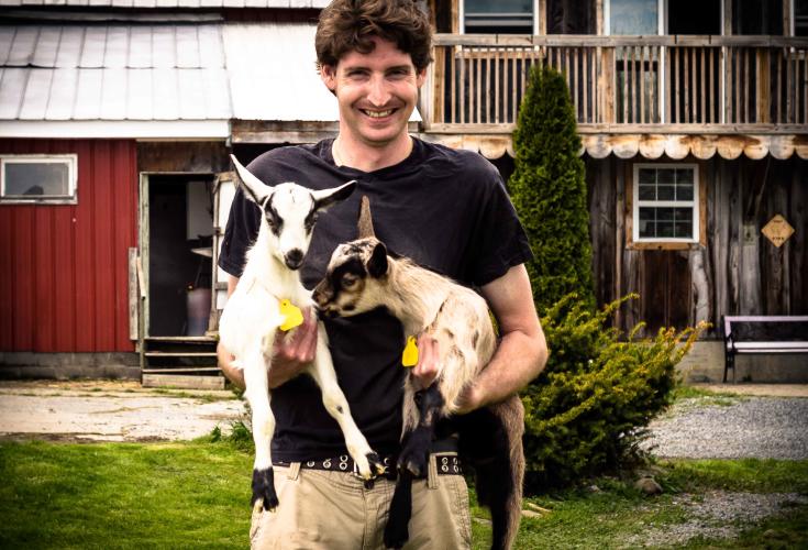 Man holding baby goat
