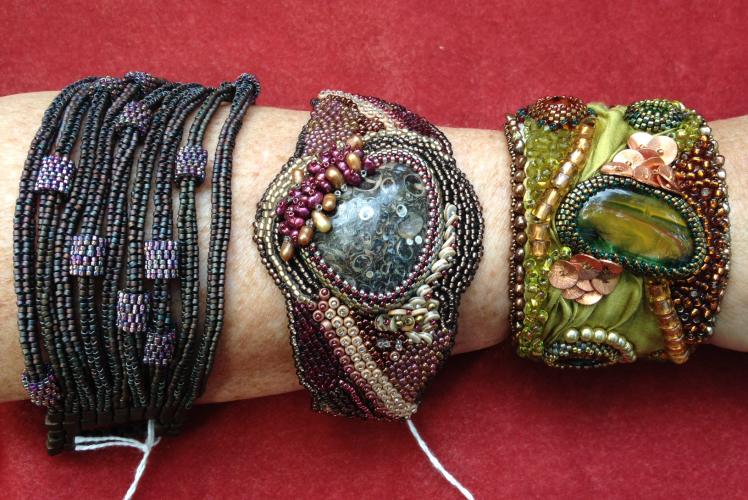 three different types of bracelets, bangle, leather backed cuff and a metal back cuff