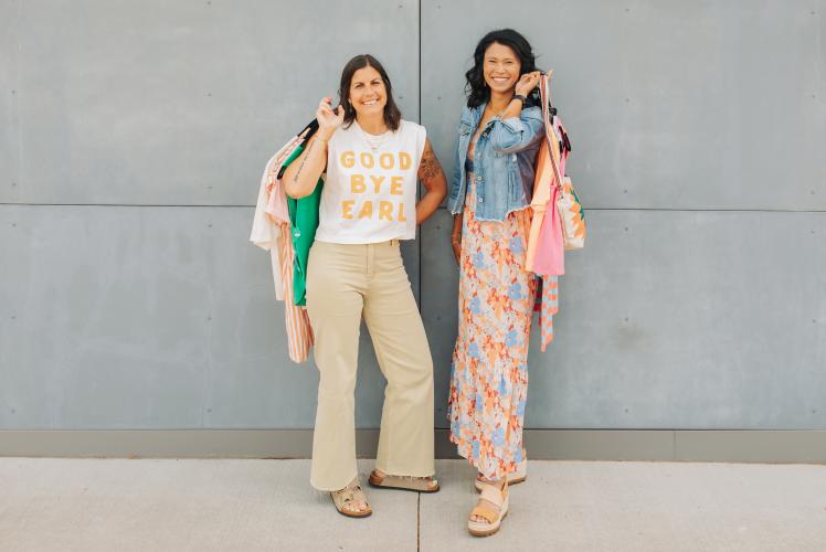 Owners of Threads Clothing Co. holding a couple of their unique clothing pieces