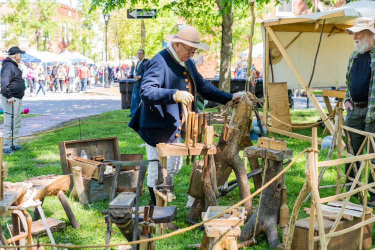 A man displays wood carvings.